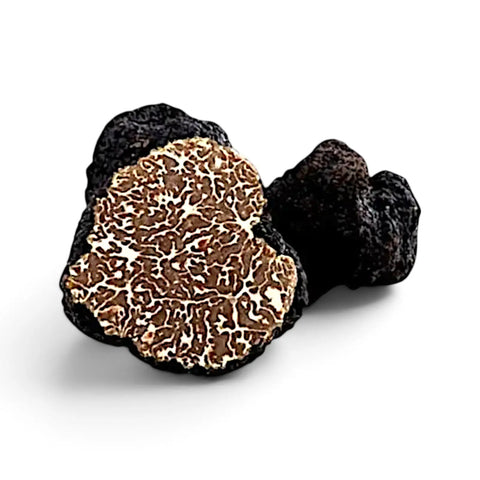 Trufas enteras y cortadas de Tuber mesentericum Bagnoli que muestran el exterior oscuro y el interior marmoleado