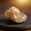 Trufas frescas Tuber borchii de Categoría EXTRA con un ejemplar cortado que muestra el interior marrón naturalmente veteado
