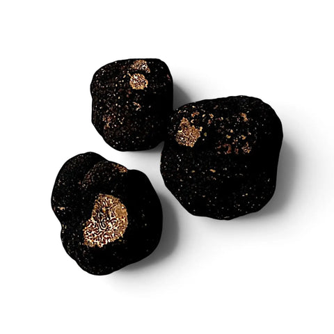 Trufas enteras y cortadas de Tuber mesentericum Bagnoli, que muestran una piel exterior oscura y un interior veteado
