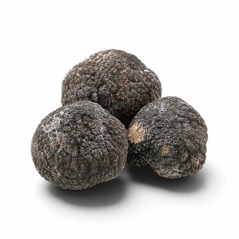 Tres trufas enteras congeladas con una ligera escarcha natural sobre un fondo blanco