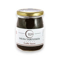 Frasco de salsa de trufa con tapa y etiqueta doradas, salsa tartufata con contenido negro
