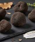 Dark truffles on a slate surface with Terra Ross label